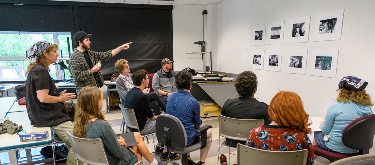 学生s and their professor reviewing art projects